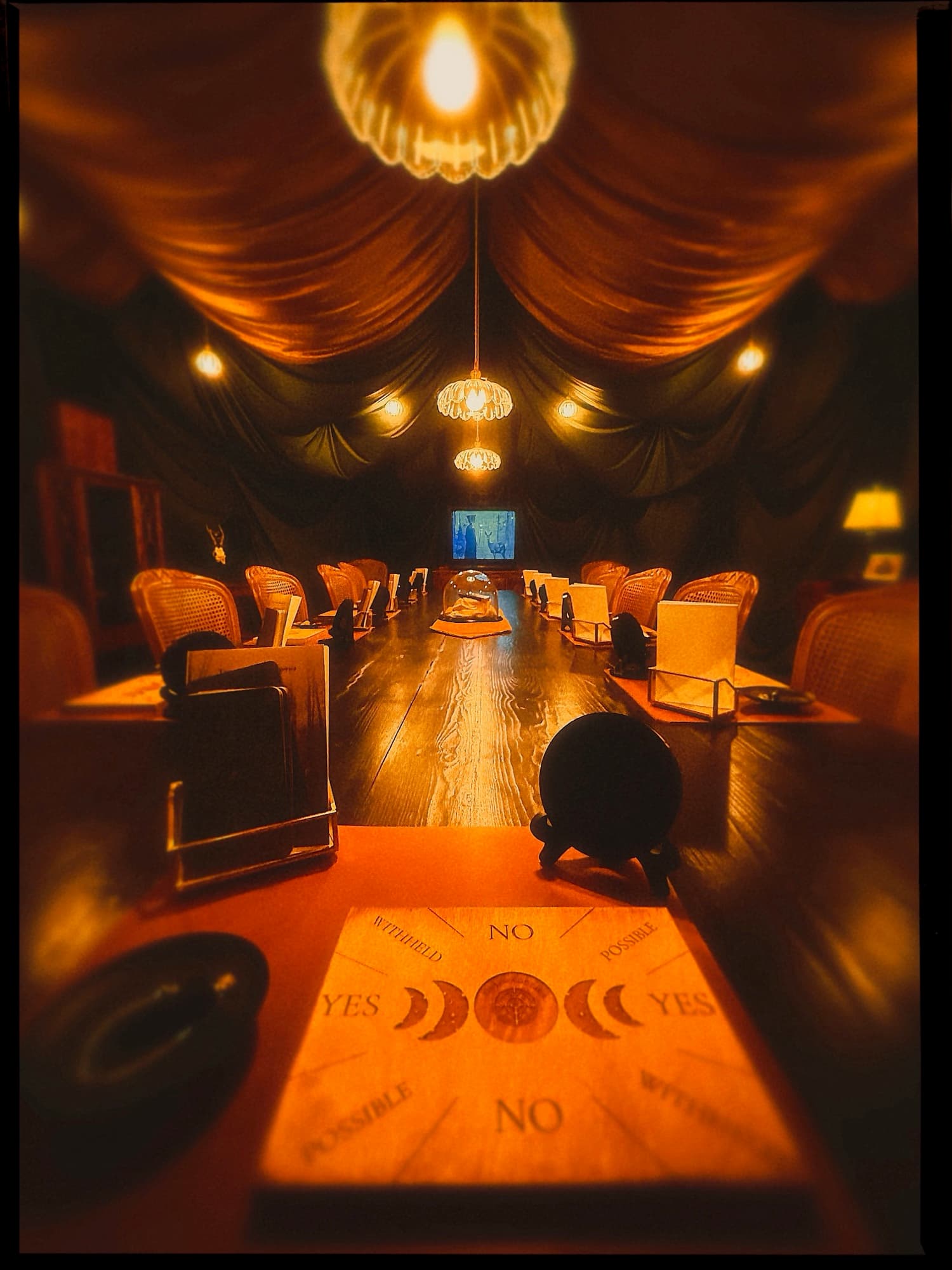 A spirit board at the head of the long séance table.